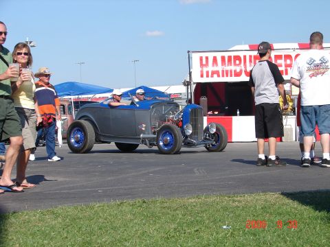 1987 Ford Bronco - A custom hot rod roadster with a two-tone gray and blue paint scheme is on display at an outdoor event.