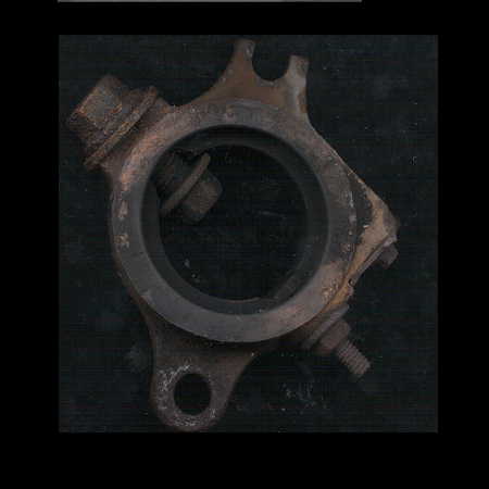 1979 Ford Bronco - A close-up view of a rusty, circular metal component with bolts attached.