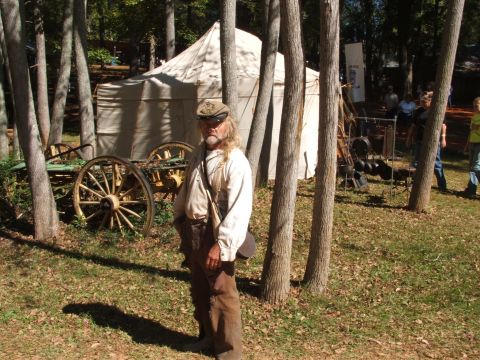 1966 Ford Ranchero - A man dressed in historical reenactment clothing stands near a tent and an antique wagon.