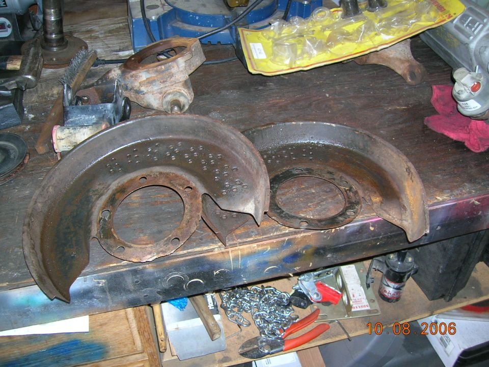 Rusty brake backing plates and parts on a workbench