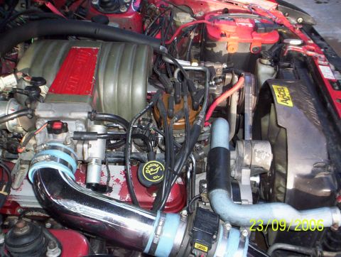 1990 Ford Mustang - Engine bay details including intake manifold, hoses, and battery are visible in this photo.