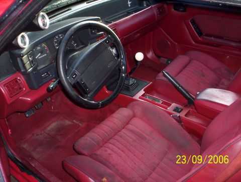 1990 Ford Mustang - The interior of a 1990 Ford Mustang shows a manual shifter and aftermarket gauges.