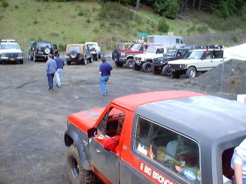 1976 Ford F-100 - A red and gray Ford Bronco is parked in a lot with other vehicles.