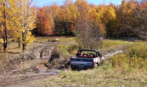 1979 Ford Bronco - A truck navigates a muddy trail during the fall season.