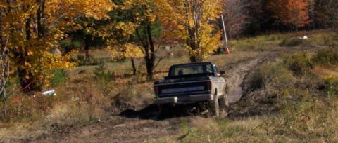 1979 Ford Bronco - 1979 Ford Bronco navigating a challenging off-road course during autumn.
