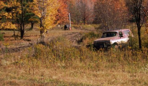 1979 Ford Bronco - An old SUV sits partially hidden in overgrown grass during autumn.