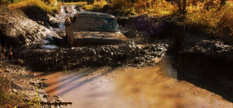 1979 Ford Bronco - This 1979 Ford Bronco is struggling to get through a muddy off-road obstacle.