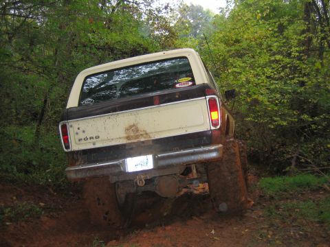 1992 Ford Mustang - This Ford Bronco is navigating a muddy, wooded trail, its off-road capabilities.