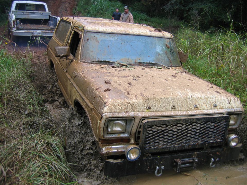 Mud-covered 1978 Ford Bronco stuck in mud, front view