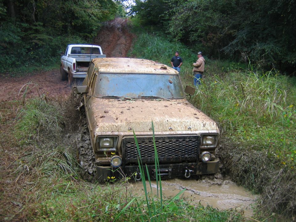 Mud-covered 1979 Ford F-Series truck stuck in mud, front view