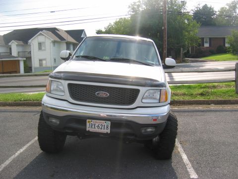 1994 Ford Bronco - This lifted 1999 Ford F-150 pickup truck is parked in a lot.