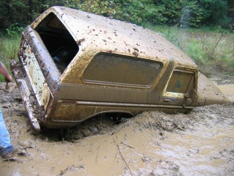 1992 Ford Mustang - This vehicle is deeply stuck in the mud, with only its tires and lower body visible.