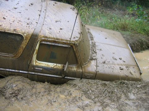 1992 Ford Mustang - This 1978 Ford Bronco is deeply stuck in mud and appears to be off-roading.