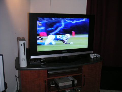 1994 Ford Bronco - A television displays a football game, accompanied by gaming consoles and controllers.