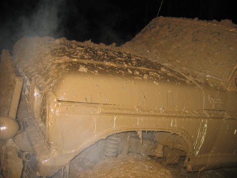 1992 Ford Mustang - Vehicle heavily covered in mud, obscuring details and model year.