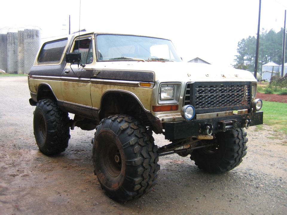 Lifted 1978 Ford Bronco with large off-road tires, a winch, and custom grille