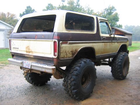 1992 Ford Mustang - This lifted Ford Bronco, likely from the late 1970s, sits on a gravel surface with a rustic background.