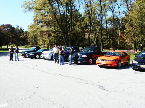 2001 Mercury Grand Marquis - Outdoor gathering with multiple vehicles including an orange Ford Mustang and several trucks and sedans.