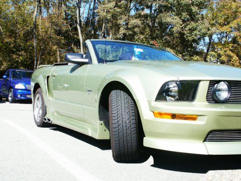 2001 Mercury Grand Marquis - A light green convertible is parked next to a blue pickup truck on a sunny day.