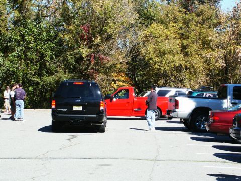 2001 Mercury Grand Marquis - Several vehicles are parked in a lot with trees in the background. A black SUV is in the foreground.