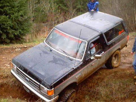 1976 Ford F-100 - This black Ford Bronco appears to be from the early 1980s, not a 1976 F-100, as it is stuck in the mud.