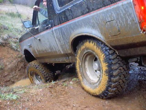 1976 Ford F-100 - This 1976 Ford F-100 navigates a muddy off-road trail, its tires caked with dirt.