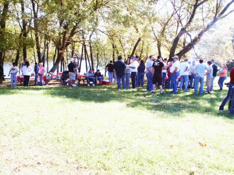 2001 Mercury Grand Marquis - A group of people enjoy a picnic outdoors by a body of water on a sunny day.
