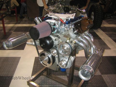 1990 Ford Bronco - highly polished V8 engine with a cone air filter, chrome accessories and short zoomie-style intake stacks sits on a steel stand at an indoo…