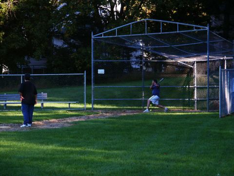 2001 Mercury Grand Marquis - Two people are at a baseball field, one is batting and the other is watching.