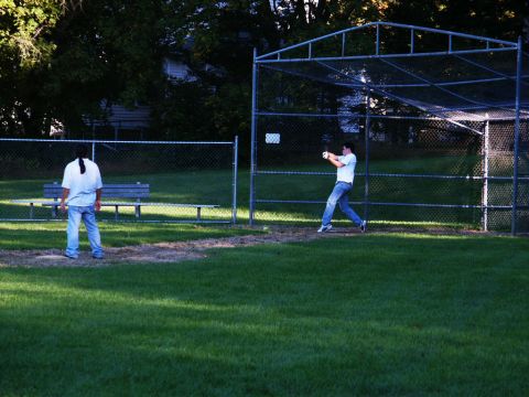 2001 Mercury Grand Marquis - Two people are on a baseball field, one preparing to bat and the other standing near a bench.