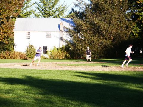 2001 Mercury Grand Marquis - Three people are playing baseball on a sunny day near a house.
