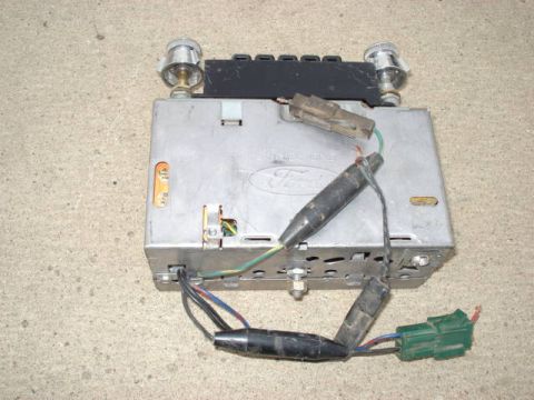 1979 Ford Bronco - A vintage Ford car radio with visible wiring and connectors is shown from a top-down perspective.