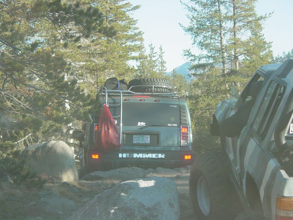 Rear view of a Hummer H2 with a roof rack and spare tire