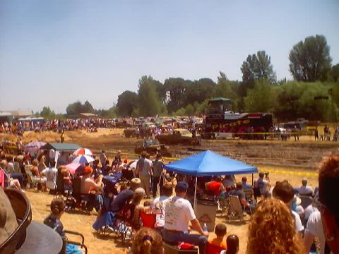 1976 Ford F-100 - Spectators watch trucks compete in a mud bog event, with a large truck labeled 'PIRATE' visible in the background.