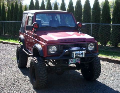 1987 Suzuki Samurai - This red 1987 Suzuki Samurai is equipped with large off-road tires and a front-mounted winch.