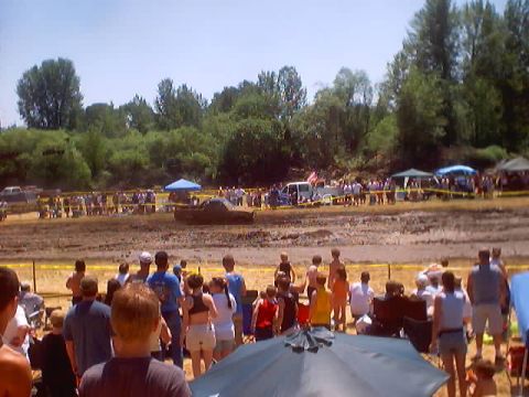 1976 Ford F-100 - Spectators watch vehicles participate in a mud bogging event on a sunny day.