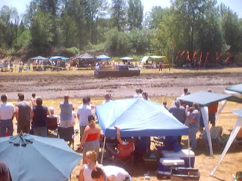 1976 Ford F-100 - Spectators gather around tents at an outdoor event in a muddy field.