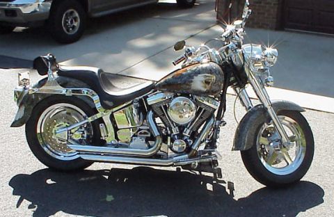 1999 Harley-Davidson Fat Boy - A custom motorcycle with chrome accents and an eagle painted on the fuel tank sits on a paved surface.
