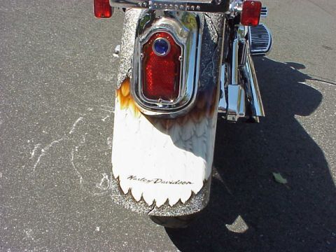 1999 Harley-Davidson Fat Boy - Motorcycle fender features custom eagle feather paint and Harley-Davidson branding.