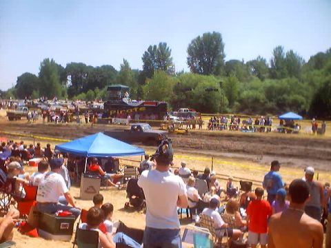 1976 Ford F-100 - Spectators watch a mud bog event with several trucks visible in the distance.