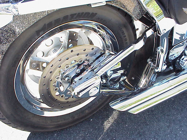 Chrome rear disc wheel, drilled brake rotor and Metzeler Marathon tire on a Harley-Davidson cruiser