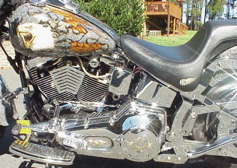 1999 Harley-Davidson Fat Boy - Close-up of a motorcycle's custom painted gas tank an eagle, alongside its engine and seat.