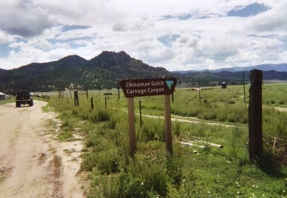 Chinaman Gulch Carnage Canyon BLM trail sign beside gravel road in Colorado valley