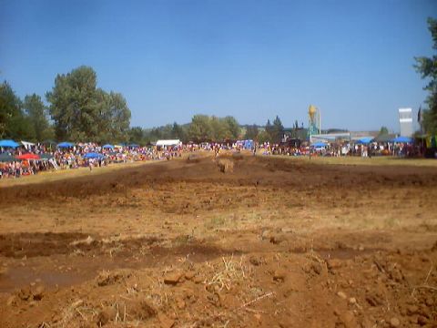 1976 Ford F-100 - A wide view of a motocross track during an event, with crowds gathered in the background.