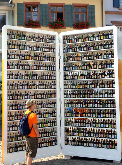 1996 Ford Probe - A person stands before a massive, open book-shaped display filled with rows and rows of beer bottles.