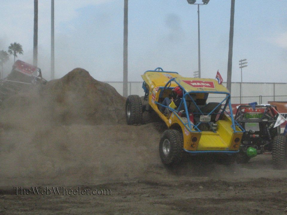 Yellow Warn-decaled buggy on a dusty dirt course with other buggies nearby