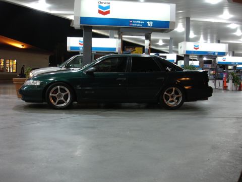 1993 Ford Taurus - A dark green sedan is parked at a gas station with Chevron pumps visible in the background.