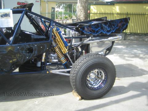 1990 Ford Bronco - Rear three-quarter view of a tube-frame off-road buggy with dark airbrushed skull artwork, gold coilover shocks and a polished aluminum rea…