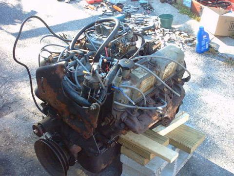 1979 Ford Bronco - Engine assembly, likely a V8, is shown disassembled and resting on concrete blocks and wood supports.