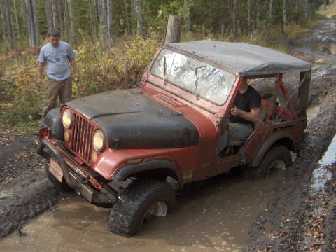 1979 Jeep CJ5 - A Jeep CJ gets stuck in a muddy trail during an off-road excursion.